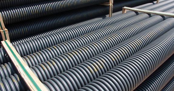 Stack of black corrugated plastic pipes