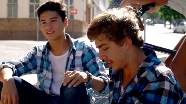 Teenagers hanging out on sunny urban street