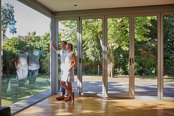 loving couple looking through glass window - window home interior women people imagens e fotografias de stock