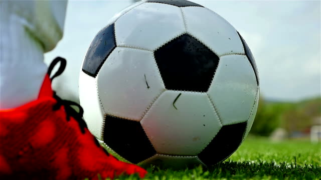 Football game. Soccer action. Goal keeper/footballer kicking a ball, slow motion