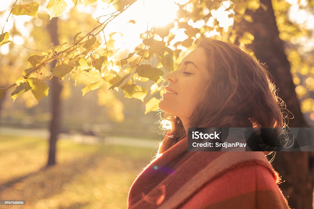 Aroma of the fall Beautiful, young, caucasian woman standing in the park and enjoying with her eyes closed Autumn Stock Photo