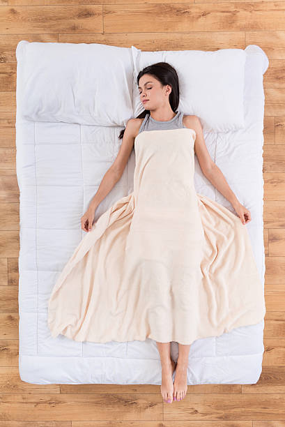 istock Nice young woman lying and sleeping on bed 596768758