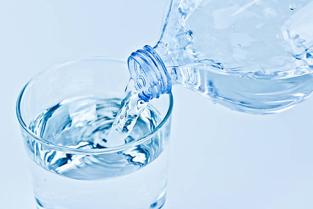 istock filling a glass with water through bottle 596770464