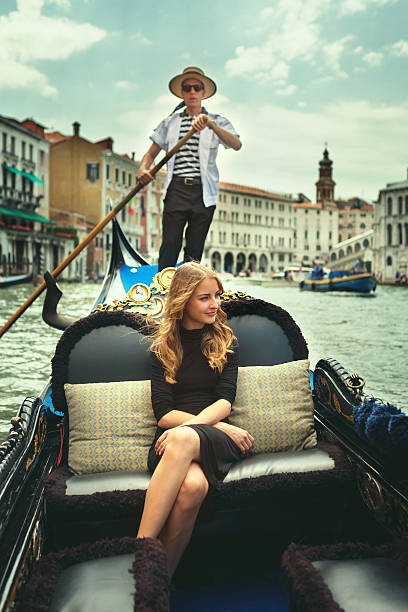 Young woman in gondola tour in Venice Beautiful girl relaxing in a gondola. gondolier stock pictures, royalty-free photos & images