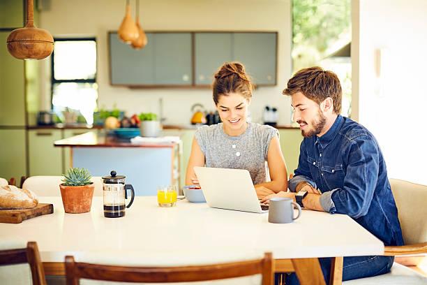 istock Happy young couple using laptop at breakfast table 596771394