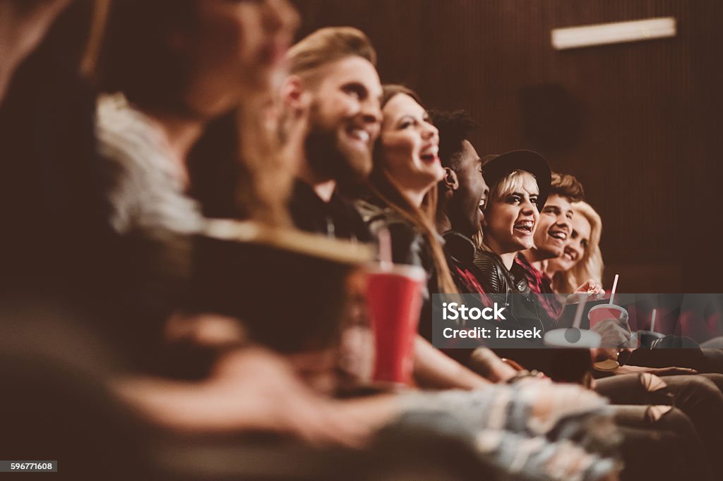 Group of people in the cinema Group of people in the movie theater. Siede view, close up of hands, legs and drinks. Movie Theater Stock Photo