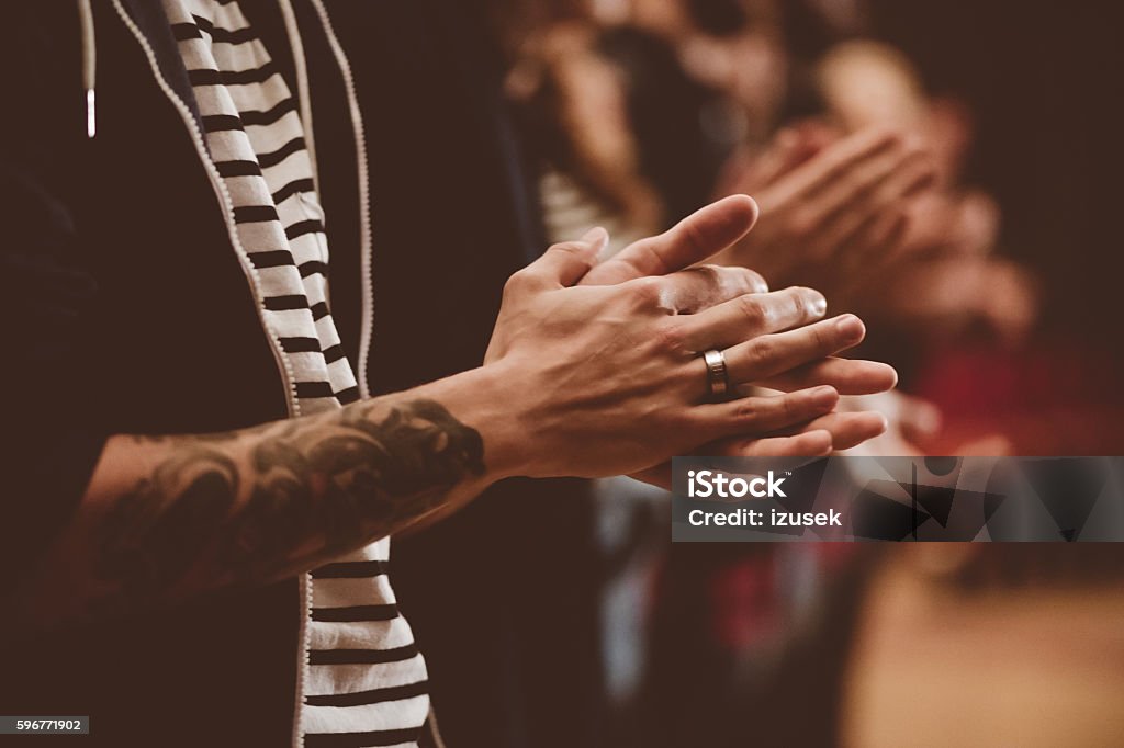 People in the theater, close up of clapping hands People in the theater. Side view. Dark tone. Focus on clapping hands. Applauding Stock Photo