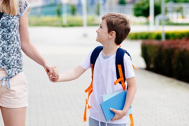 istock Boy with his mother at road to school. 596772256