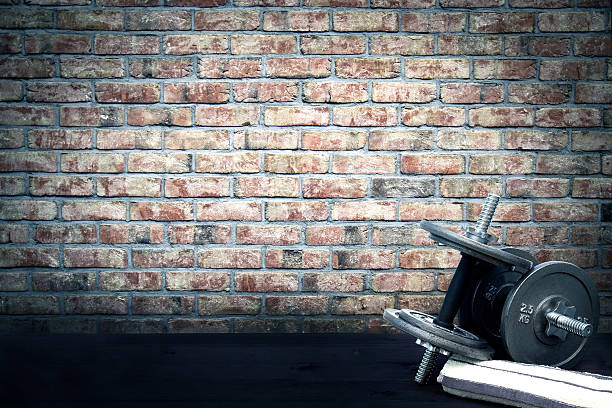 istock Dumbbells and towel lying on the ground in vintage stylization. 596772318