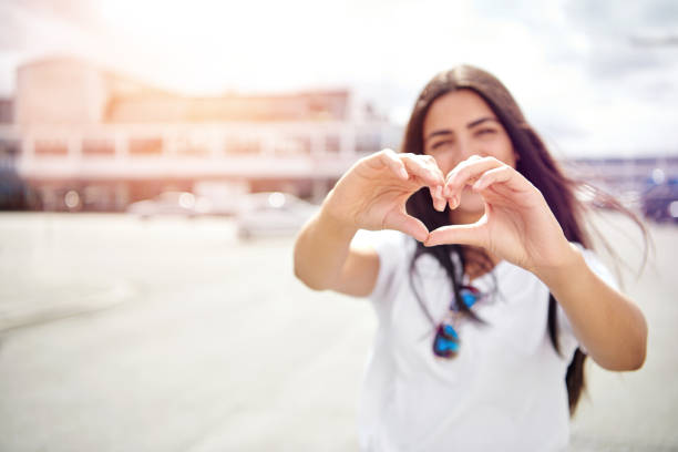 istock Pretty romantic young woman making a heart sign 596773848
