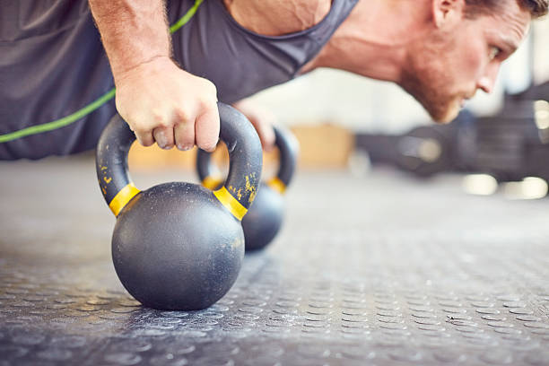 istock Determined fit man doing push-ups on kettlebells at gym 596779738