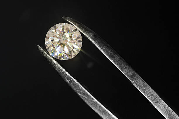 istock Diamond being inspected with tweezers 596780886