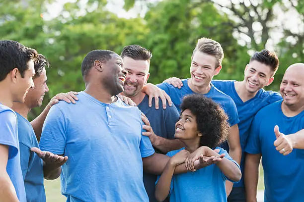 Photo of Black man in group getting pat on back