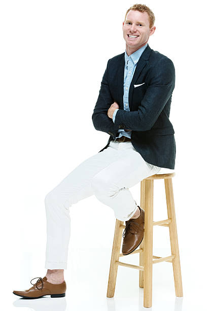 istock Fashionable man sitting on stool 596786776