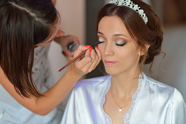 istock Stylist makes makeup bride on the wedding day 596787560