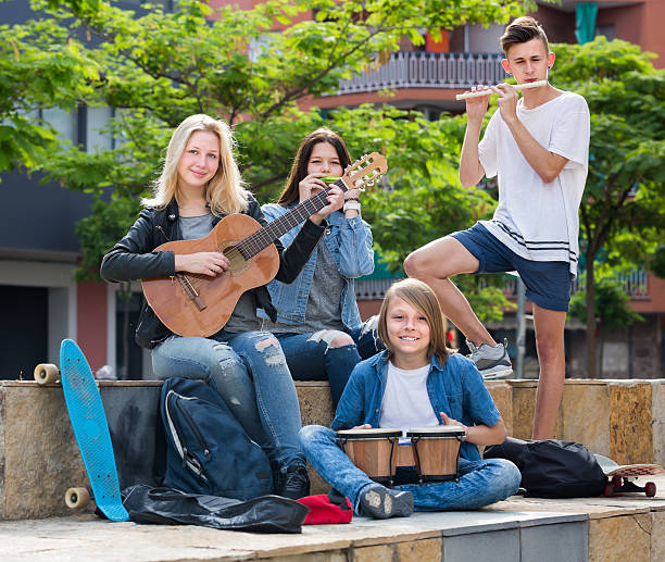 istock Happy girls and boys with musical instruments 596788990