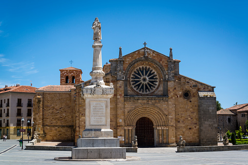  Avila, Castilla y Leon, Spain - July 12, 2016: Romanesque church of San Pedro and the monument to St Theresa at the Plaza Santa Teresa in the centre of the city