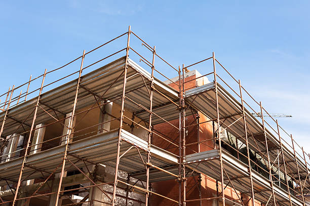 istock House for renovation with the scaffolding for bricklayers 596792444