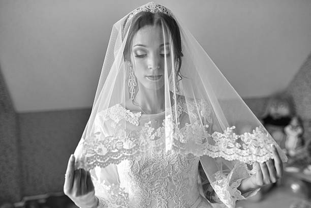 istock Beautiful bride under a transparent veil on wedding day 596792844