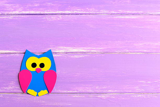 istock Cute paper owl isolated on a bright wooden background 596792938