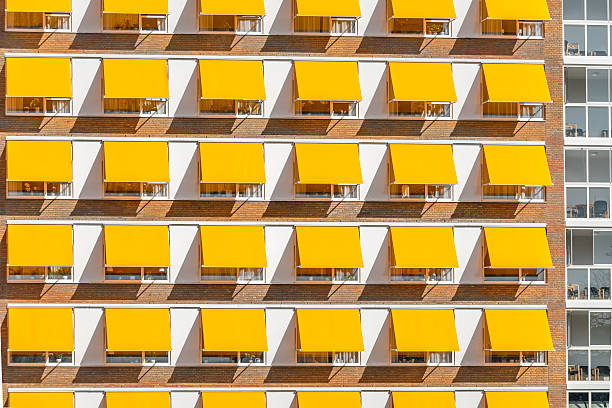 The iconic facades of traditional Amsterdam canal houses, photographed on October 31, 2022. These characteristic buildings showcase narrow designs with large windows and gabled rooftops, reflecting the historical architecture and charm of the Dutch capital. The image captures the symmetry and details that make these homes a quintessential part of Amsterdam's urban landscape.
