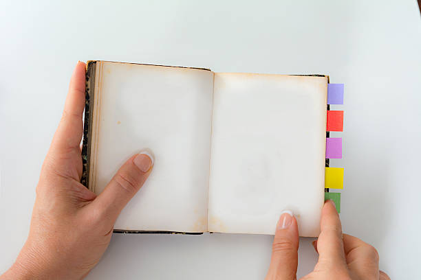 istock Personal perspective woman opening an old color tabed book 596796248