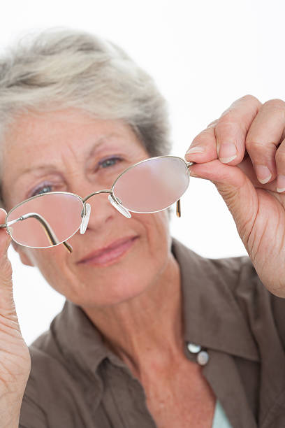 istock senior woman examining glasses 596797872