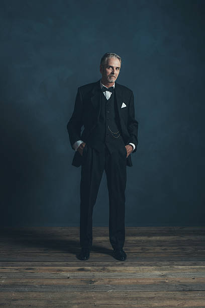 Confident middle aged retro 1920s businessman in black suit.