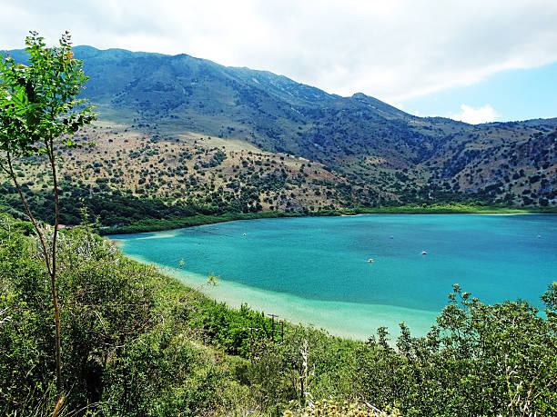 istock sunbeds near mountain lake Greece 596800132