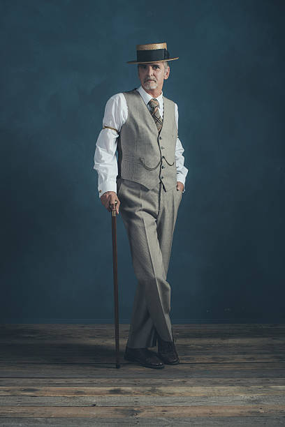 Retro 1920s dandy in suit standing with cane.