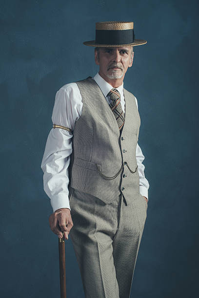 istock Retro 1920s dandy in suit standing with cane. 596800298