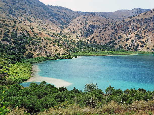 istock sunbeds near mountain lake Greece 596800534