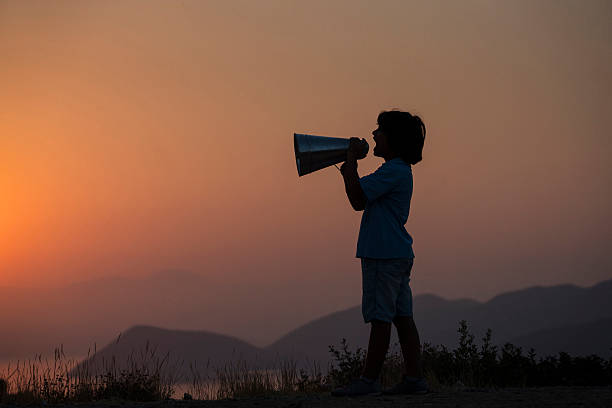 young boy shouting in megaphone - marketing megaphone child using voice imagens e fotografias de stock