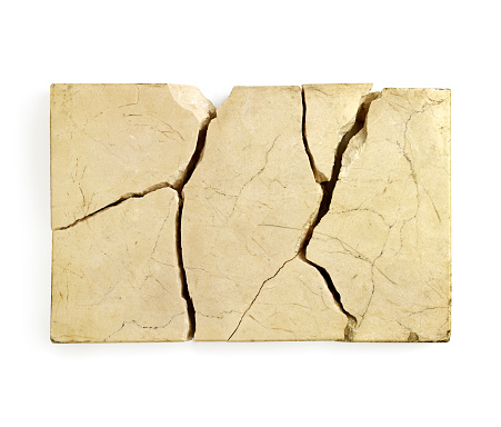 Yellow color piece of cracked marble against white background