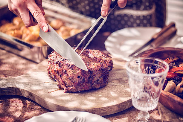 istock Cutting Roast Beef with Potatoes and Root Vegetables 596802542