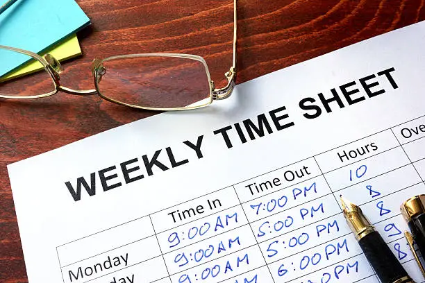 Photo of Paper with weekly time sheet on a table.