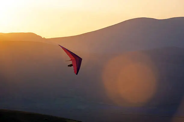 An ultralight plane against sunset sky ,hang Glider Pilot Launching,lens flare,Castelluccio,Apennines,Italy,Nikon D3x