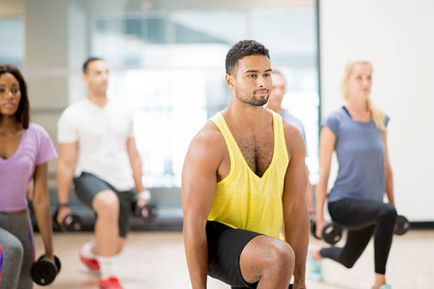 istock Drop Lunges in a Fitness Class 596804406
