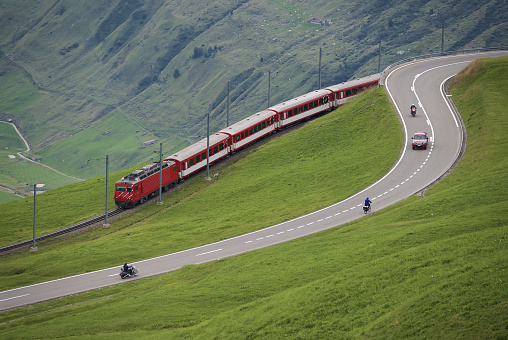 Andermatt, Switzerland - August 20, 2016: Train of the Matterhorn Gotthard Bahn near Andermatt in Switzerland. The train is on its way from Dissentis in canton Graubünden to Brig in canton Valais and descends from the Oberalp pass in canton Uri.