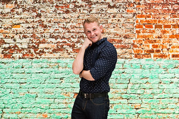 istock Smiling man in front of brick wall 596805724