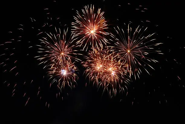 Beautiful colorful red and orange holiday fireworks on the black sky background