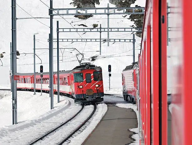 Two trains of the Matterhorn Gotthard Bahn (MGB) crossing at Oberalp pass height.