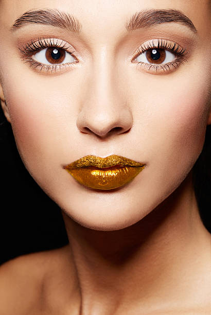 Closeup of woman face.perfect skin, gold lips,long eyelashes. stock photo