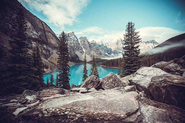 The crystal clear blue water of Moraine Lake surrounded by the Canadian Rockies. Banff National Park, Alberta.