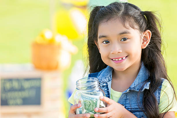 istock Little girl with lemonade stand profits 596814070