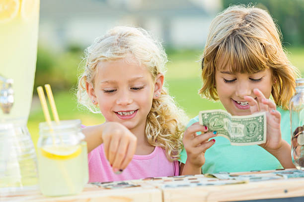 istock Sisters sell lemonade in front yard of home 596814118
