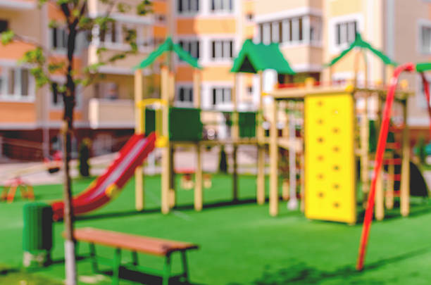 Defocused and blurred image for background of children's playground. Children's playground in the courtyard of a multistory building in sunny weather