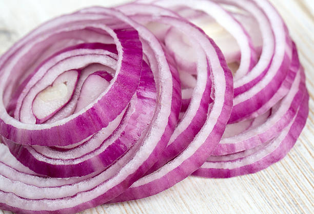 istock slices of red onions on white wooden surface 596817310
