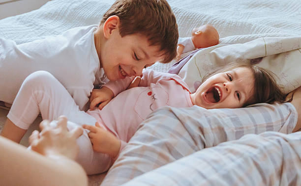 istock Relaxed mother and sons playing over the bed 596818078