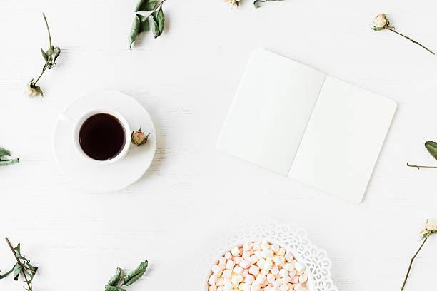istock Workspace with notebook, cup of coffee and dried rose flowers 597210896